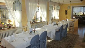A dining area with long tables set for a meal, white tablecloths, and blue chair covers. - Ferienwohnung Schlossberg Studio- 2 Personen, 60qm, 1Schlafzimmer, 2 Balkone (Bad Reichenhall)