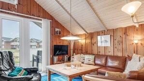 Un salon chaleureux avec un canapé en cuir, une table basse en bois et un téléviseur.