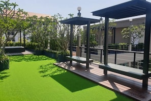 A rooftop garden with artificial grass, wooden decking, and two gazebos. - Pearl Villa (Hua Hin)