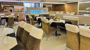 Un restaurante con asientos tipo cabina, mesas con manteles y una zona de bar.