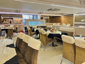 Um restaurante com assentos em cabines, mesas com toalhas e um espaço de bar.