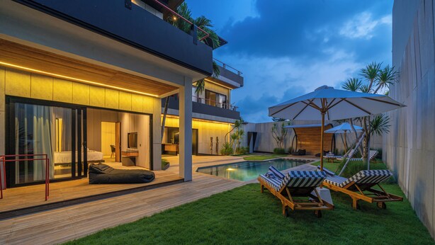 A modern house with a swimming pool, outdoor seating, and a well-maintained lawn. - Villa Sunset Berawa (Canggu)