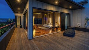 A modern bedroom with a large bed, a TV, and a balcony. - Villa Sunset Berawa (Canggu)