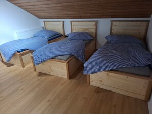 A room with three wooden beds, each with a headboard and a mattress. - Apartment 'Wohnung Aussicht' with Wi-Fi (Wald)