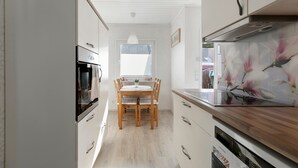 Een keuken met een eettafel, kasten en een koelkast.