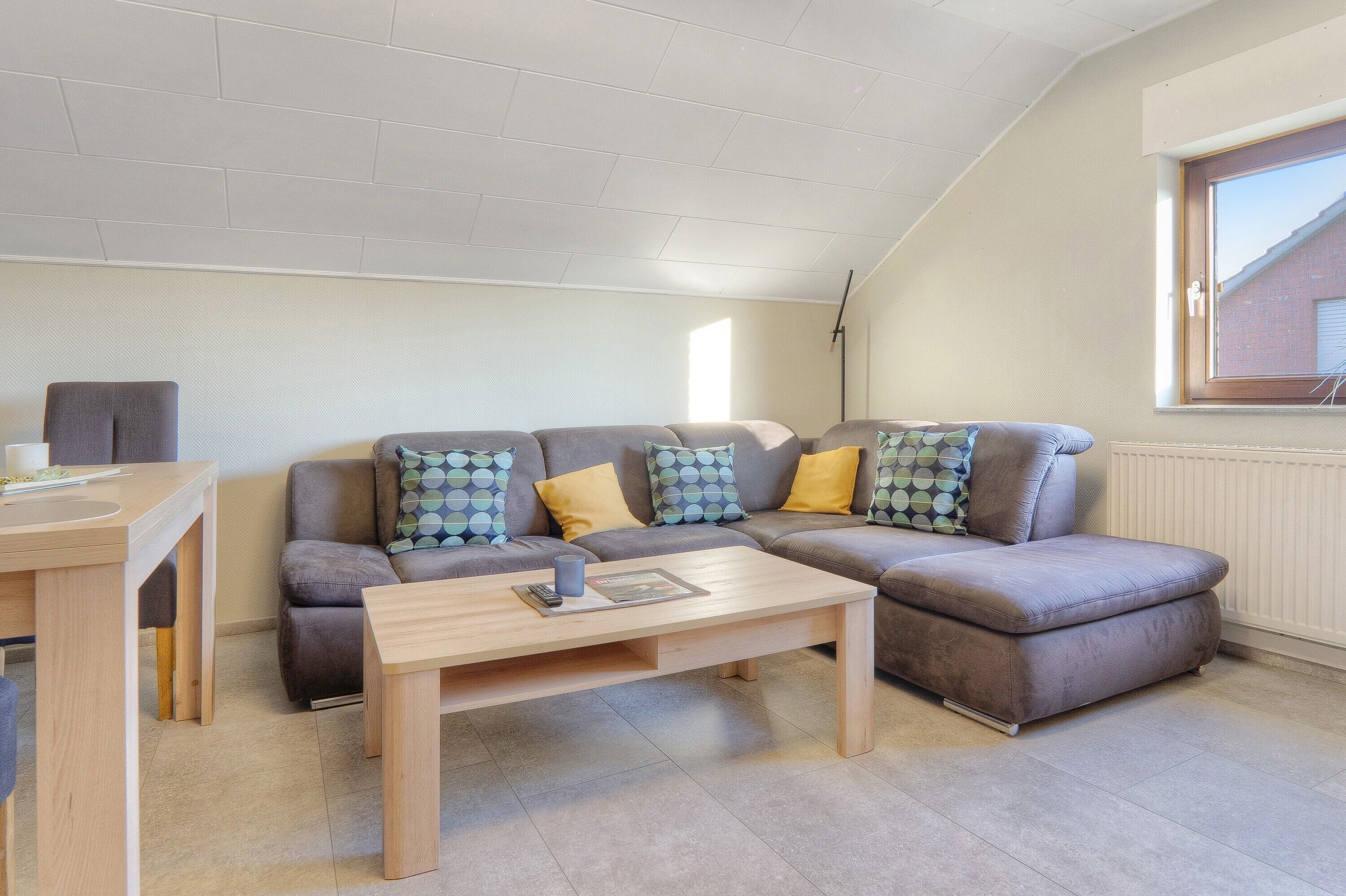 A modern living room with a sofa, a coffee table, and a window.
