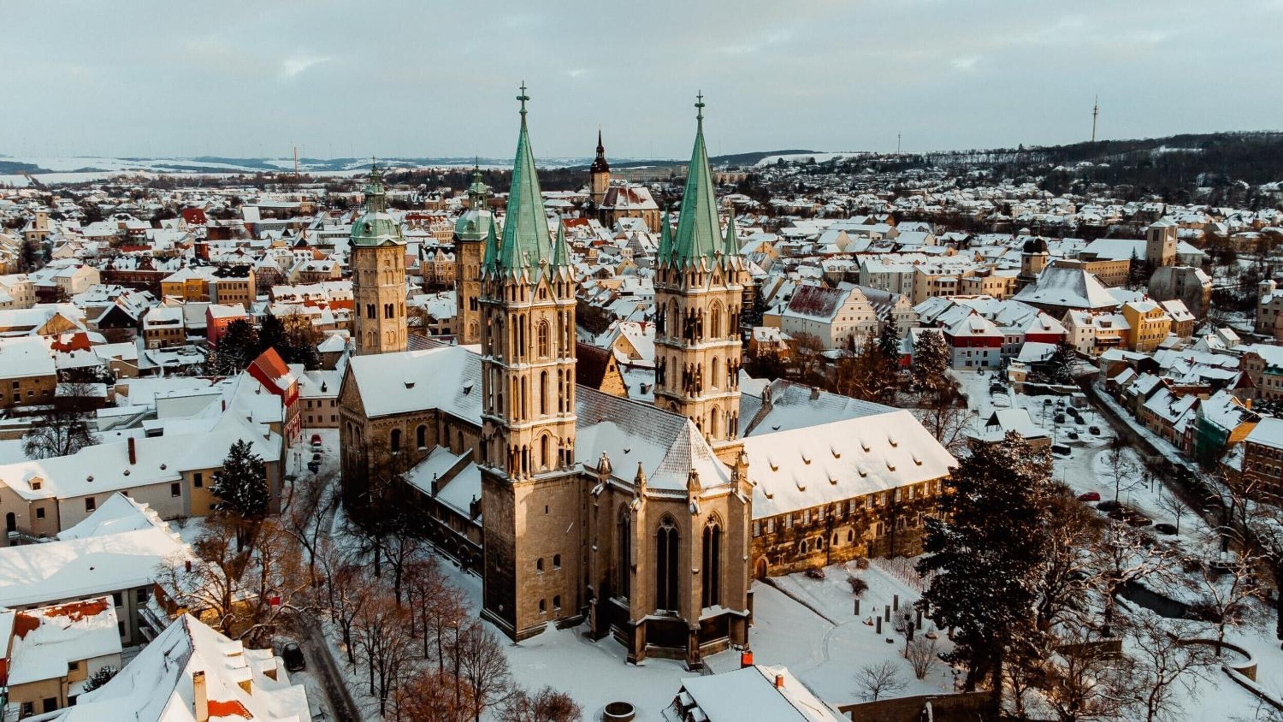 Una iglesia histórica con múltiples agujas, rodeada por un pueblo cubierto de nieve.