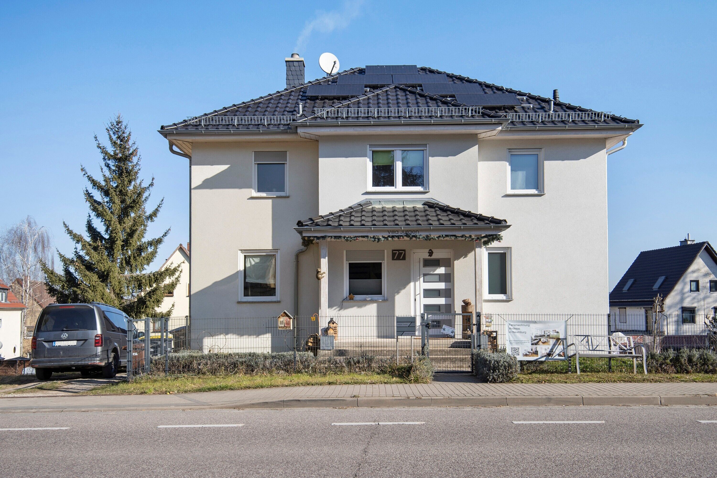 Ein zweigeschossiges Haus mit einem Ziegeldach, einer Sat-Anlage und einem Briefkasten.