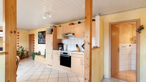 Een moderne keuken met houten kastjes, een ingebouwde oven en een betegelde spatwand.