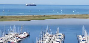 A marina with boats docked and a large ship in the background. - Apartment 'Ferienwohnungen Seestern- Ostsee' with Private Terrace, Private Garden and Wi-Fi (Wendtorf)