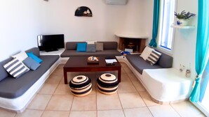 Ein Wohnzimmer mit einer Sofagarnitur, einem Couchtisch und einem Kamin.