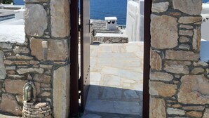 Ein Steinkorbbogen führt zu einer Terrasse mit Blick aufs Meer.