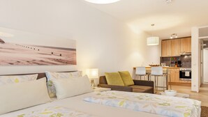 A hotel room with two beds, a sofa, a dining area, and a kitchen. - Vacation apartment '2' with Wi-Fi (Meersburg)