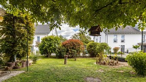 A well-maintained garden with a variety of plants and a bird feeder. - Quiet, Modern Apartment with Garden near Lake Steißlingen and Lake Constance (Steißlingen)