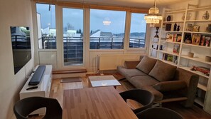 Un salon moderne avec un canapé, une table à manger et une bibliothèque.