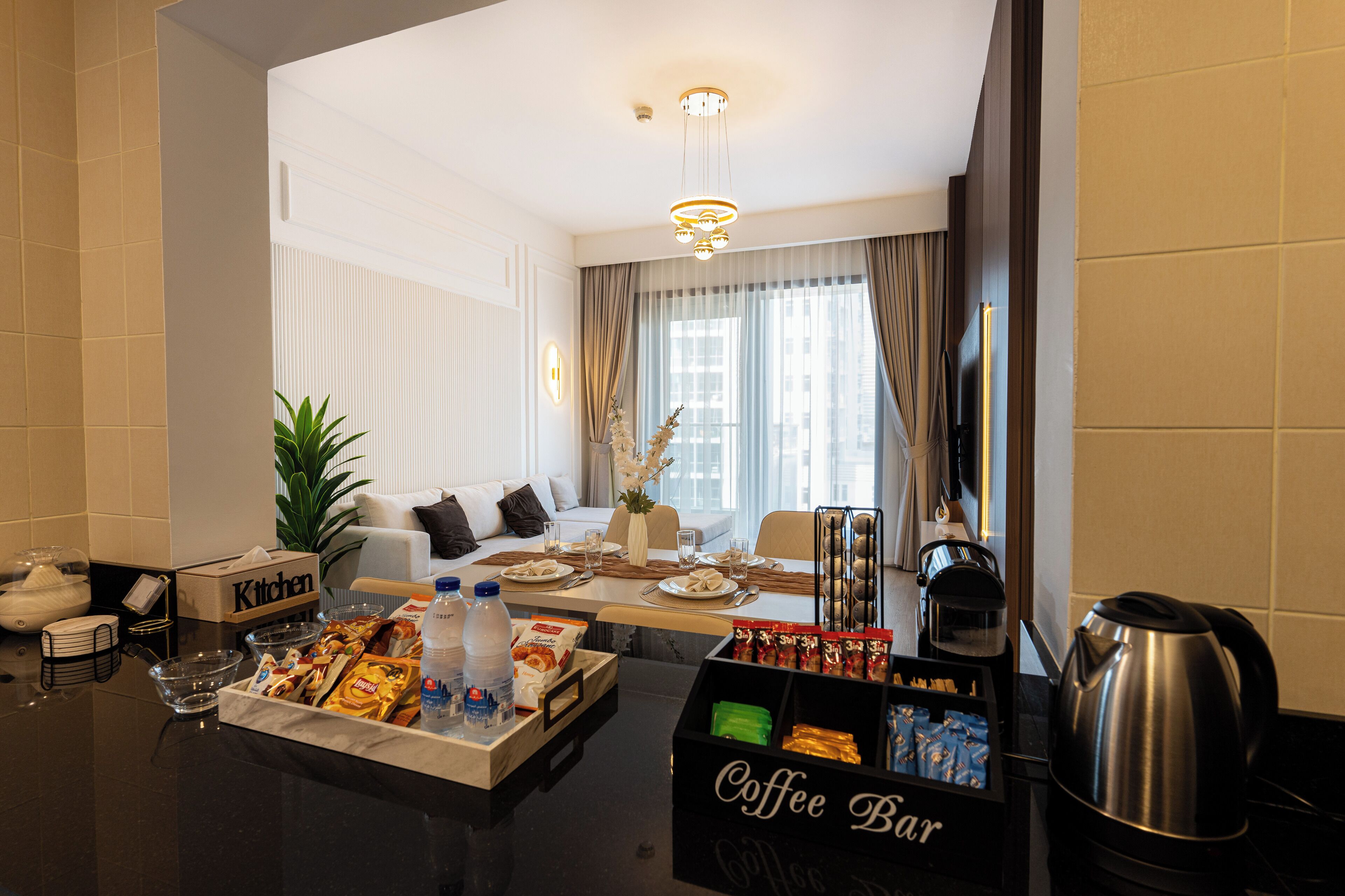 Ein modernes Hotelzimmer mit Essbereich, einer Kaffeoecke und einer Küchenzeile.