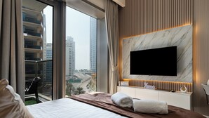 A hotel room with a large bed, a TV mounted on the wall, and a view of the cityscape through the window. - Dubaiashome - Luxury Special Stay (Dubai)