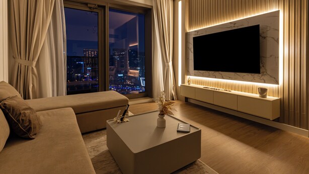 A modern living room with a large flat-screen TV, a sofa, and a coffee table. - Dubaiashome - Luxury Special Stay (Dubai)