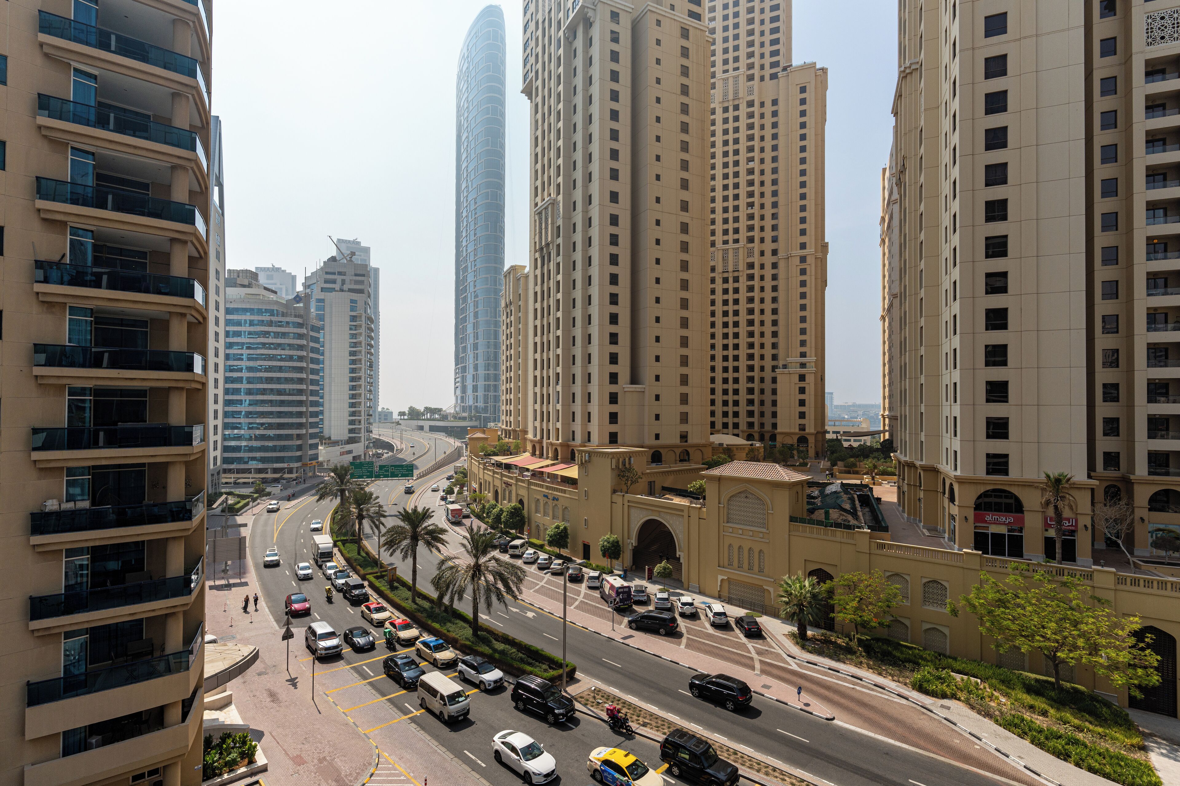 A high-rise building with multiple balconies and a curved glass facade.