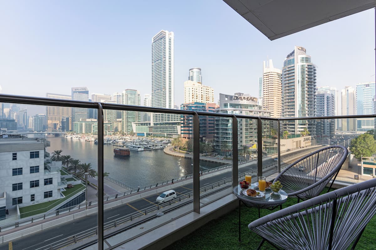 A balcony with a view of a marina and city skyline.