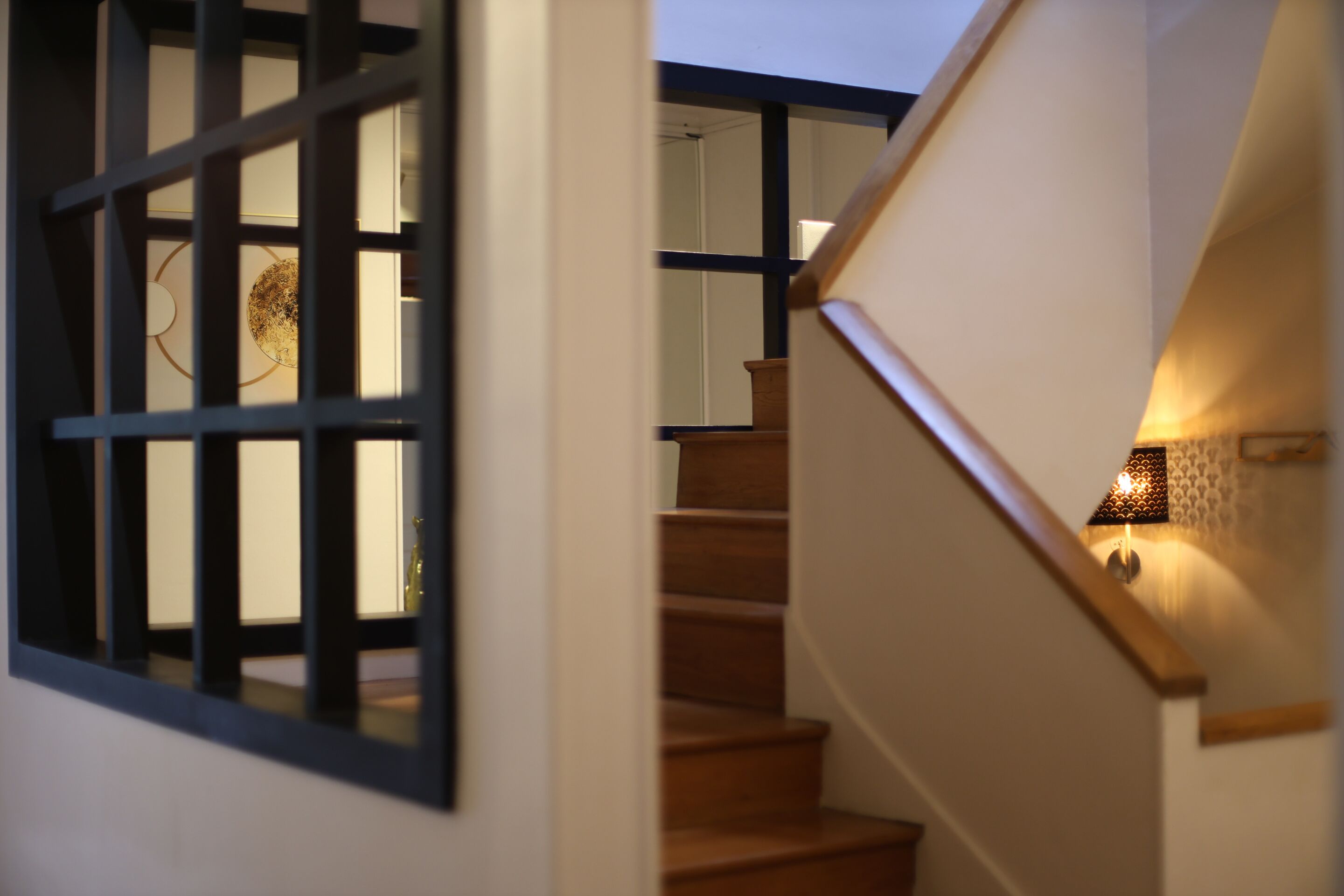 A staircase with wooden steps and a handrail, leading to an upper floor.