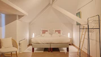 Ein Schlafzimmer mit einem Bett, zwei Nachttischen, einem Sessel, einem Heizkörper, einer Wasserflasche und einer Leiter.