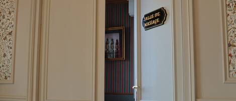 A room with a bed, a door with a sign, and a patterned wall.