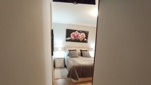 Un dormitorio con cama, mesitas de noche y un cuadro en la pared.