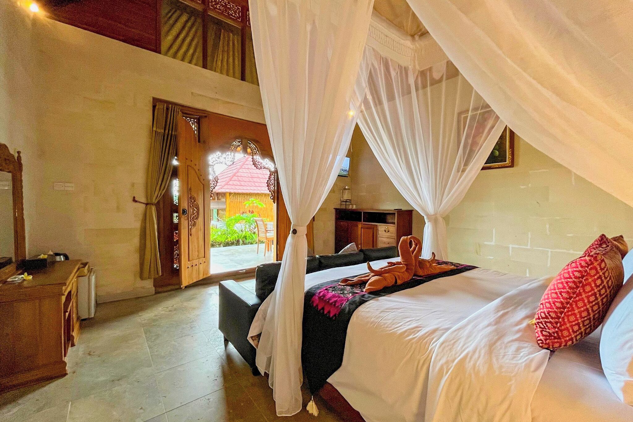 Une chambre à coucher avec un lit, un bureau et une chaise. Il y a une fenêtre avec des rideaux et une vue sur l’extérieur.