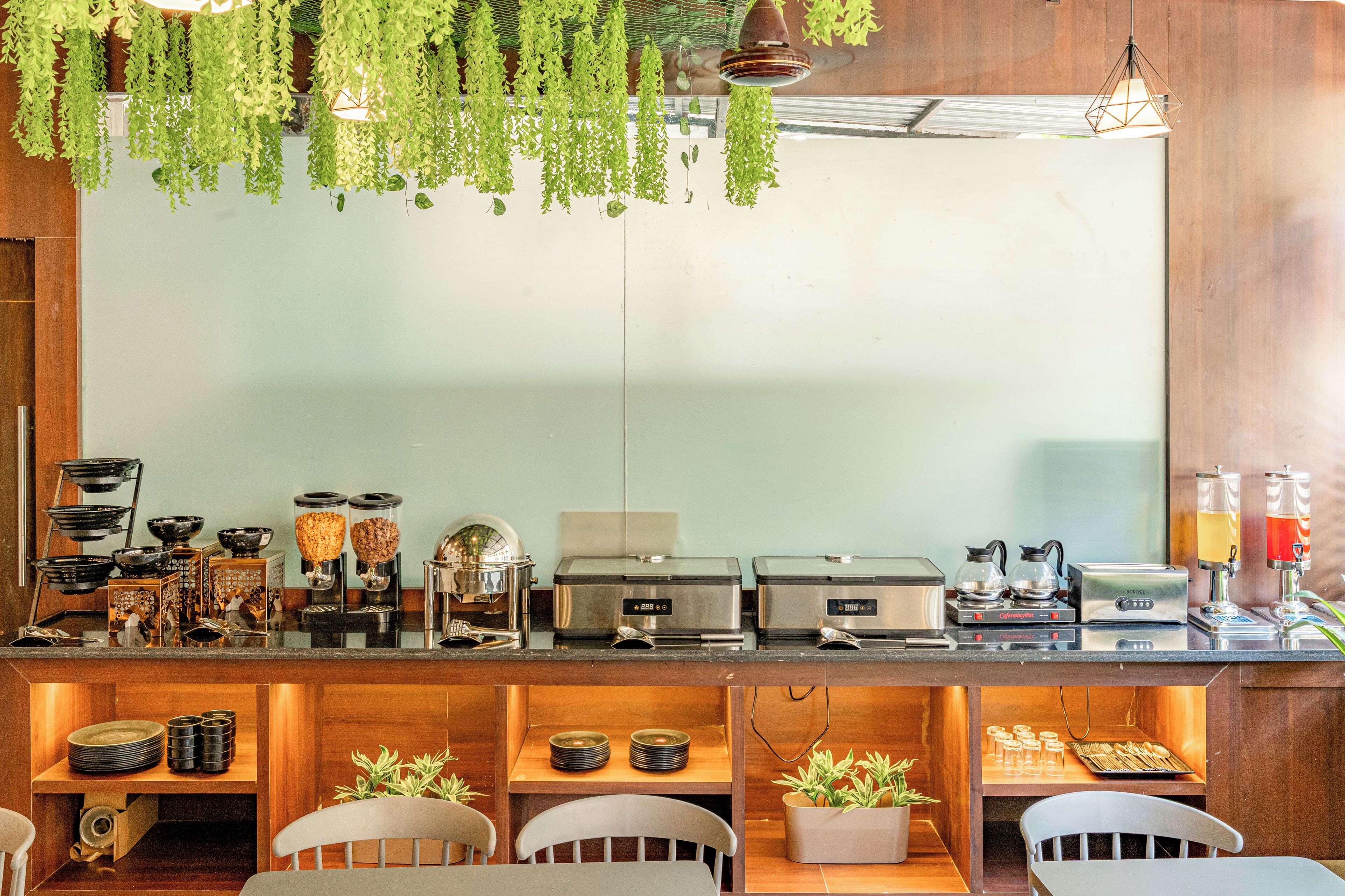 A buffet setup with various food stations, including a coffee machine and a beverage station.