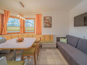 A dining area with a table, chairs, and a bowl of fruit. - Apartment in Brixen im Thale With Parking (Brixen im Thale)