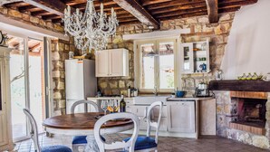A rustic kitchen with stone walls, a wooden dining table, and a fireplace. - Villa with private pool, hot tub. Quiet area & 100% privacy. panoramic views! (Umbria)