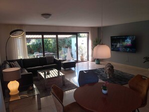 A modern living room with a sofa, coffee table, and a TV mounted on the wall. - Spacious townhouse (Essen)