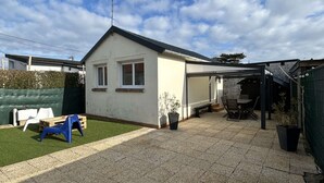 A house with a covered patio area, a small lawn, and a fenced garden. - La maison d'Oscar, 200m plage (Asnelles)