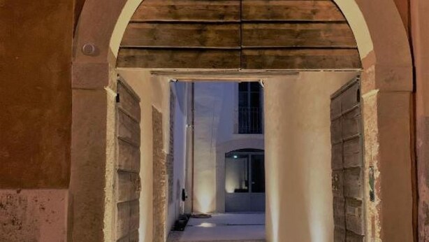 Un pasillo con techo de madera y una puerta a la derecha.