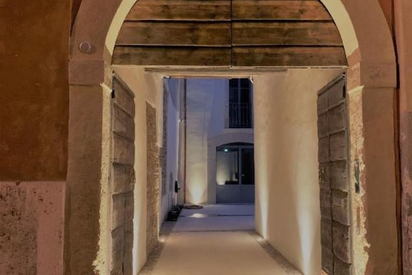 A corridor with a wooden ceiling and a door on the right.