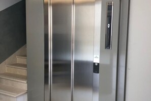 Moderni hissi, jossa on metallinhohtoinen pinta ja ohjauspaneeli.
