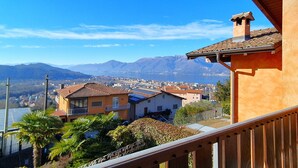 A residential area with houses, a clear sky, and mountains in the background. - House in Luino with Green Garden and City Views (Luino)