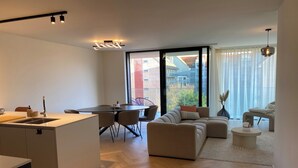 A modern apartment with a kitchen, dining area, and living room. - Apartment in Nieuwpoort near Marina (Nieuwpoort)