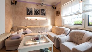 Un salon avec un canapé beige, une table basse en verre et un projecteur fixé au mur.