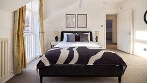 A bedroom with a large bed, a radiator, a window with curtains, and a door. - The Hampstead Getaway - Charming 5bdr Home With Conservatory (London)