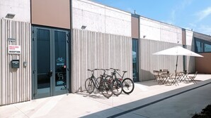 A building with a reception area, bike parking, and outdoor seating. - Bed and Bike Hostel  (San Giovanni in Persiceto)