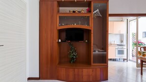 Eine Holzunterhaltungseinrichtung mit Fernseher, Regalen und einer Zimmerpflanze.