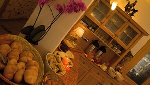 Una cocina con armarios de madera, una mesa de comedor con pan y huevos, y un ventanal con vistas.