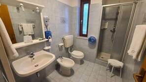 Tweepersoonskamer | Badkamer | Een douche, een haardroger, handdoeken, zeep