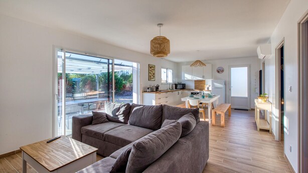 A modern apartment with a living room, dining area, and kitchen.