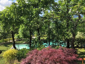 A lush garden with a swimming pool, surrounded by various trees and shrubs. - Villa Dei Poeti (16 people) by VILLAS & RETREATS, featuring a large pool, air conditioning, and a BBQ, near the Cinque Terre (Canova)