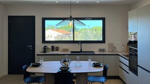 Una cocina moderna con comedor, un ventanal y vistas al exterior.
