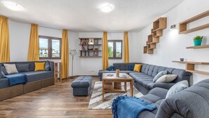 Uma sala de estar moderna com um sofá seccional, uma mesa de centro e prateleiras embutidas de madeira.