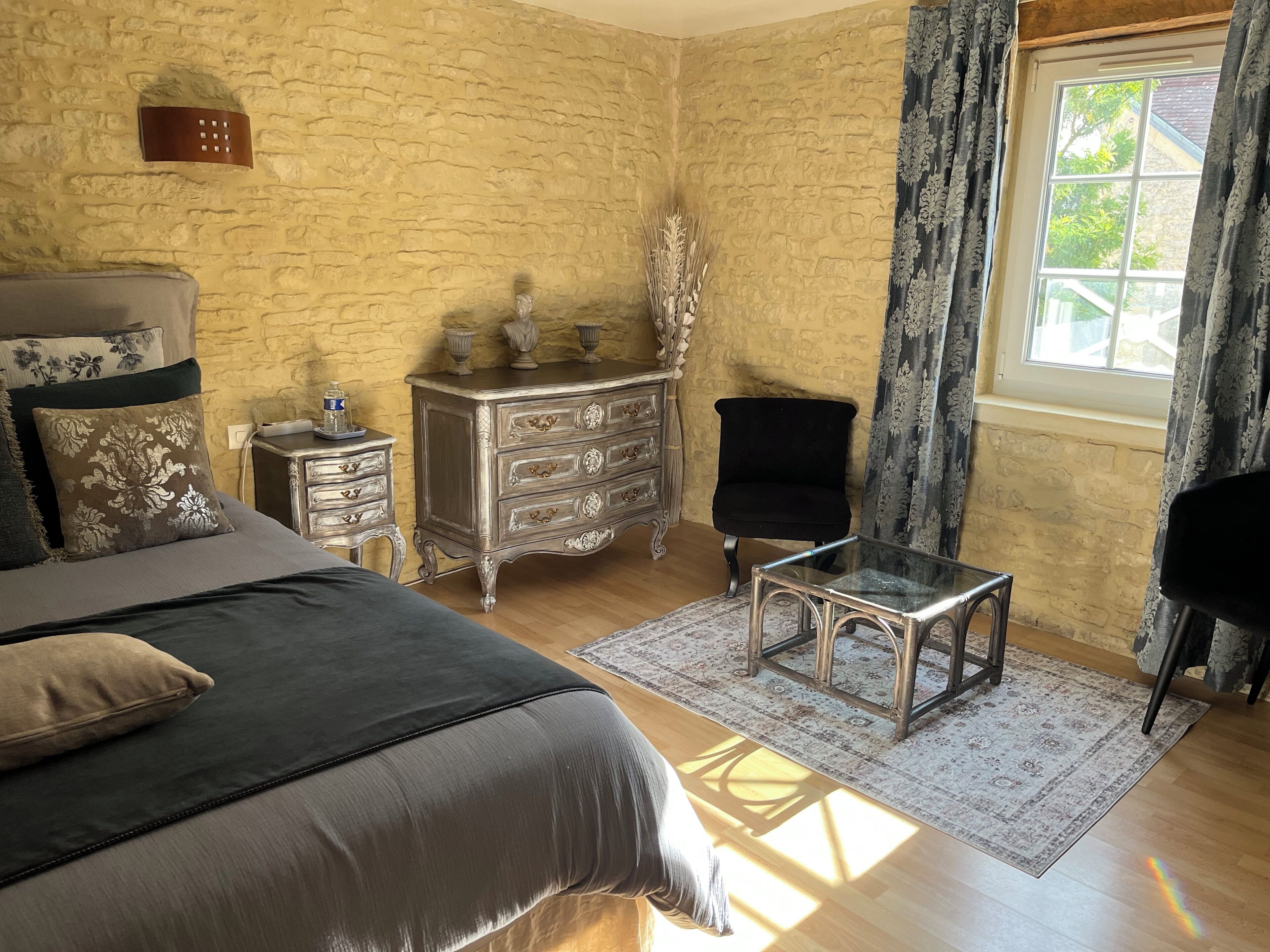 Un dormitorio con cama, cómoda, silla y mesa.